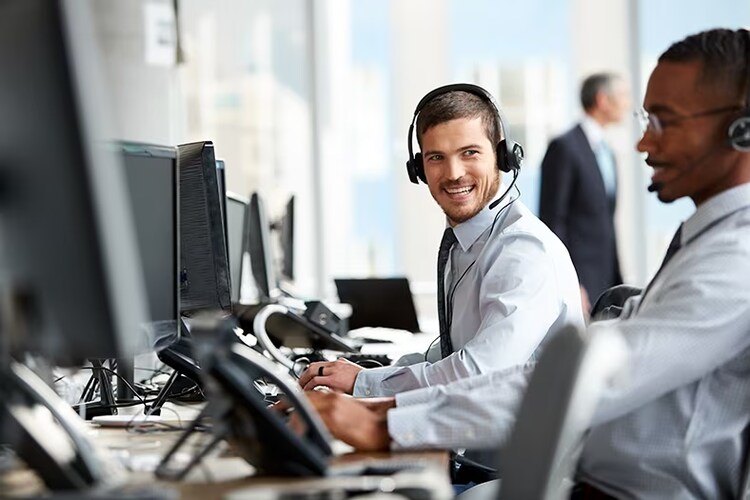 Two men conversing at their computers