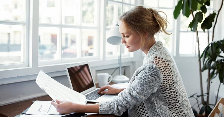 Shot of a young woman reading papers while working on a laptop at homehttp://195.154.178.81/DATA/i_collage/pu/shoots/804608.jpg