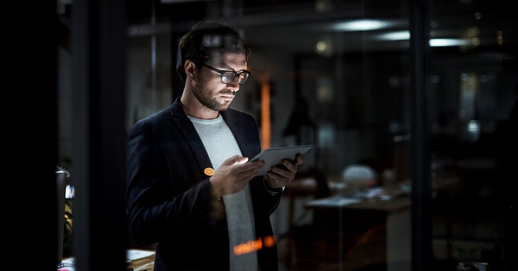 Shot of a young businessman using a digital tablet at work