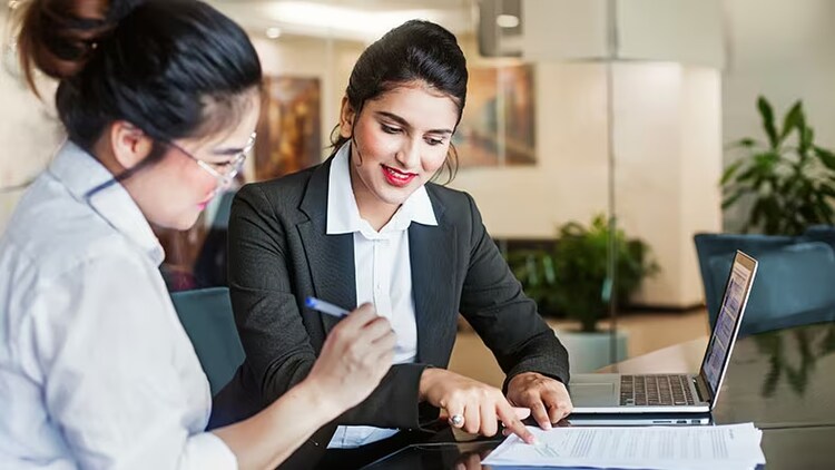 Financial services experiences: two women looking at documents