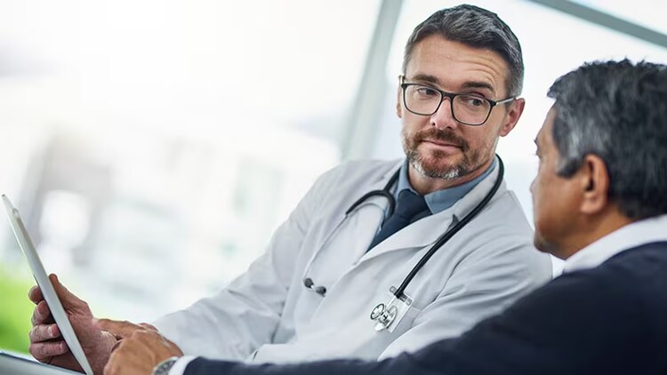 Healthcare security: A doctor and patient discuss information on a tablet.