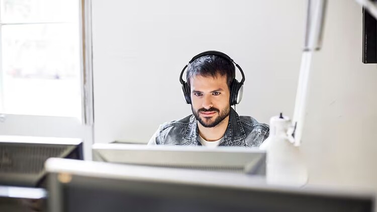 A system administrator sits at a computer monitor.