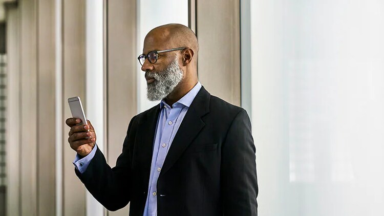 Telecom services: A business man looks at his phone.