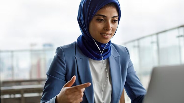 Customer experience: Young woman with headphones working on a laptop