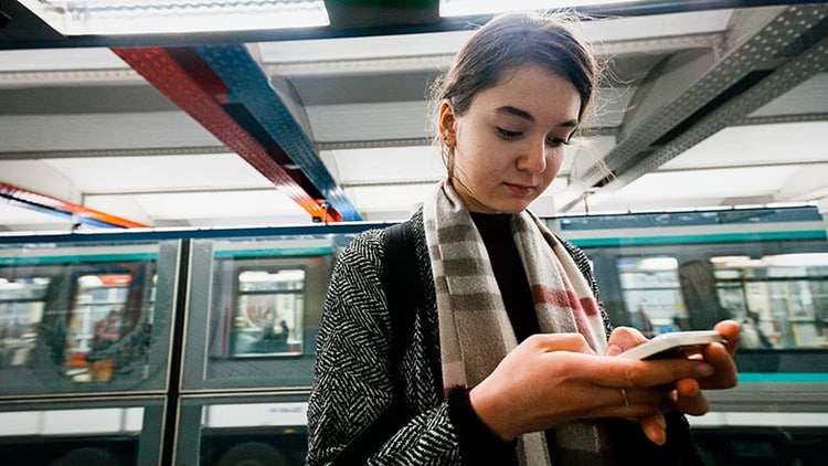 Data security: A woman does something on her smartphone in a public place.