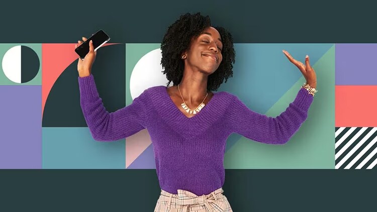 A women with her arms up while holding a phone.