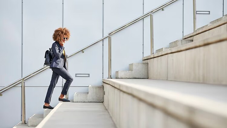 Business agility: A businesswoman climbs stairs while talking on her cellphone.