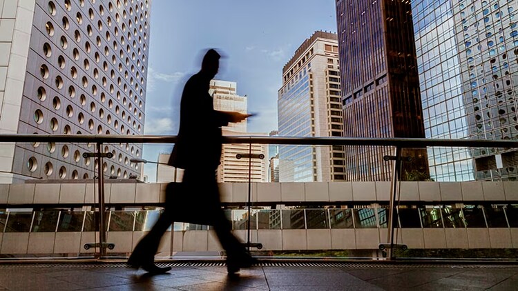 Business optimization: A businessman walking in front of a cityscape