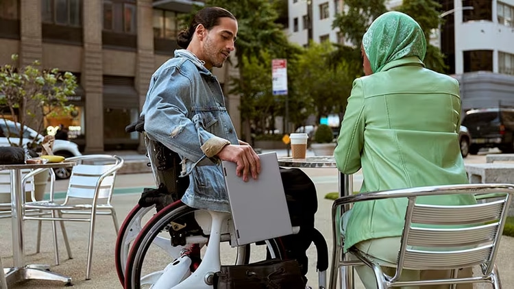 Inclusion: A worker in a wheelchair sits with another worker outside.