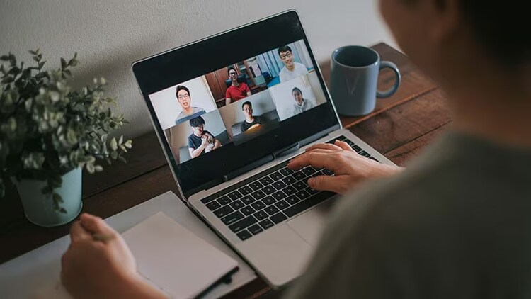 Hybrid work environment: person sitting in front of a laptop on a video call