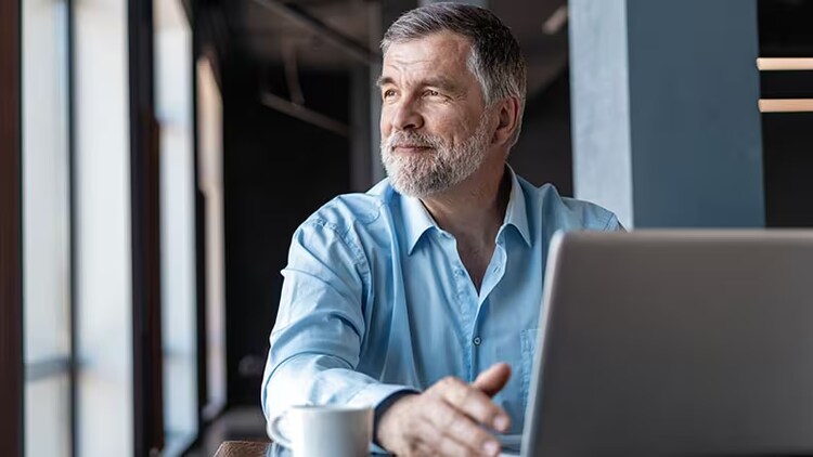 Agile value metrics: man in front of a laptop looking out a window