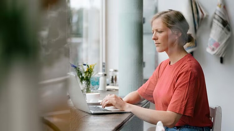 New world of work: woman sitting at table working on a laptop