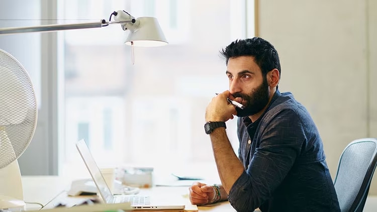 Automation and low-code set stage for innovation: contemplative man in front of open laptop