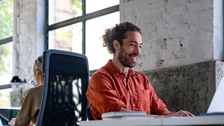Employee satisfaction: smiling man working in office