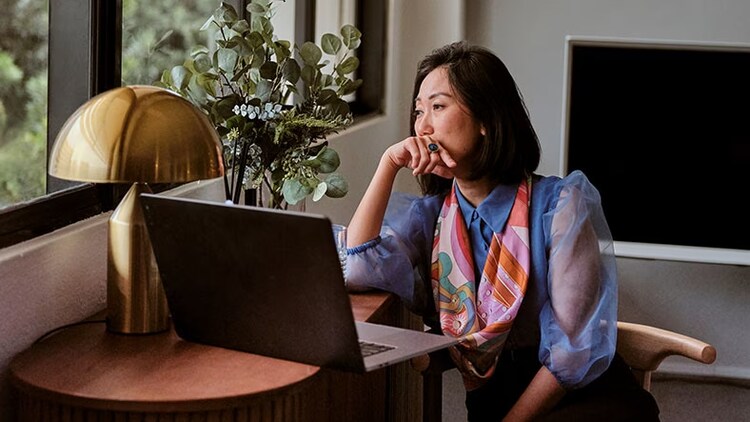 Customer service: woman in front of laptop staring out window