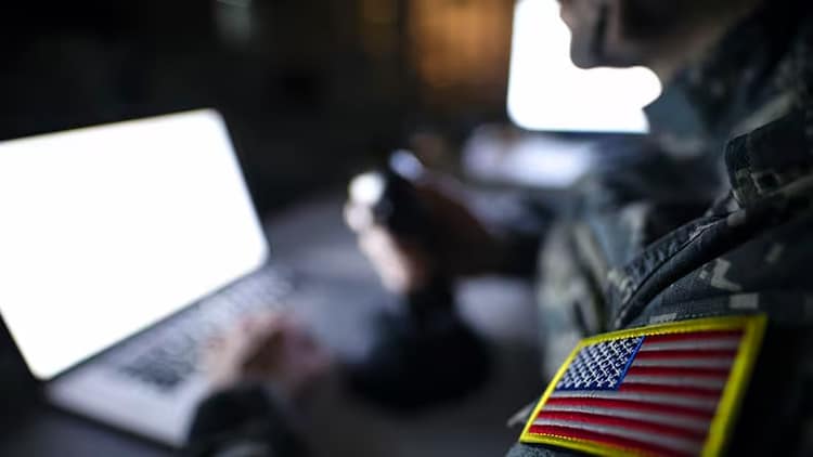 Government security: US flag on sleeve of person sitting in front of a laptop