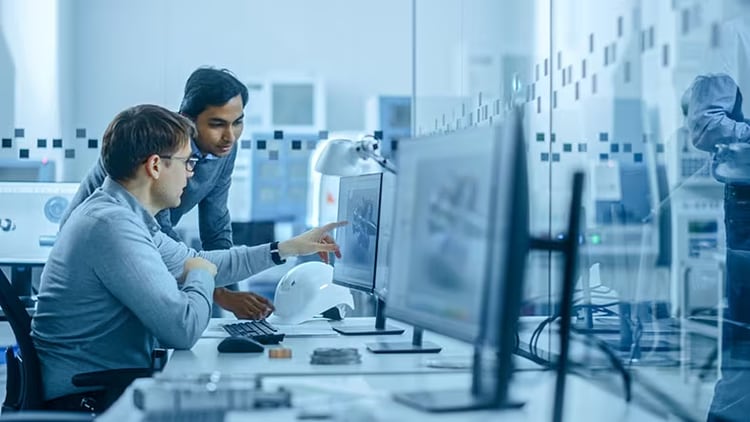 Automation jobs: two co-workers look at a computer monitor in an office