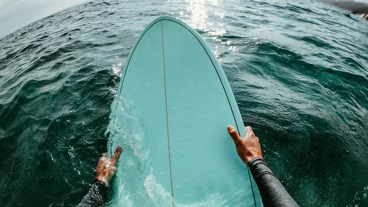 San Diego release: surfer holding a surfboard in the ocean