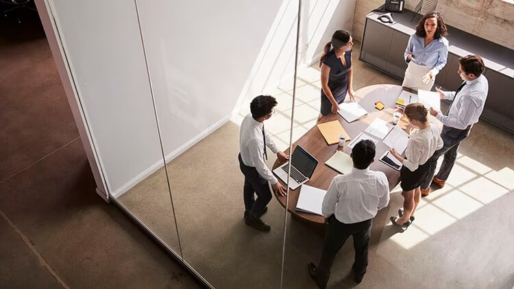 Operational excellence: group of workers standing around a conference table