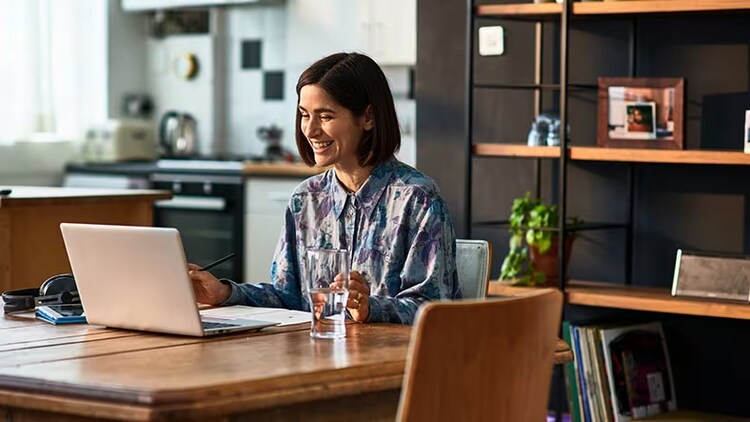 Employee productivity: female worker smiling at her laptop