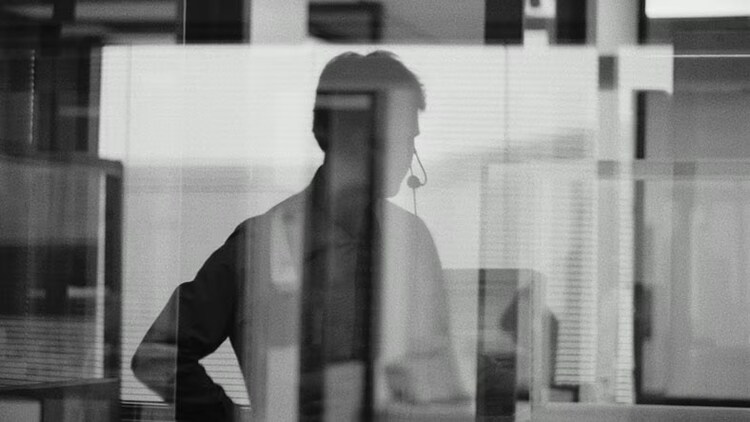 Customer service: silhouette of a businessman wearing a headset in an office