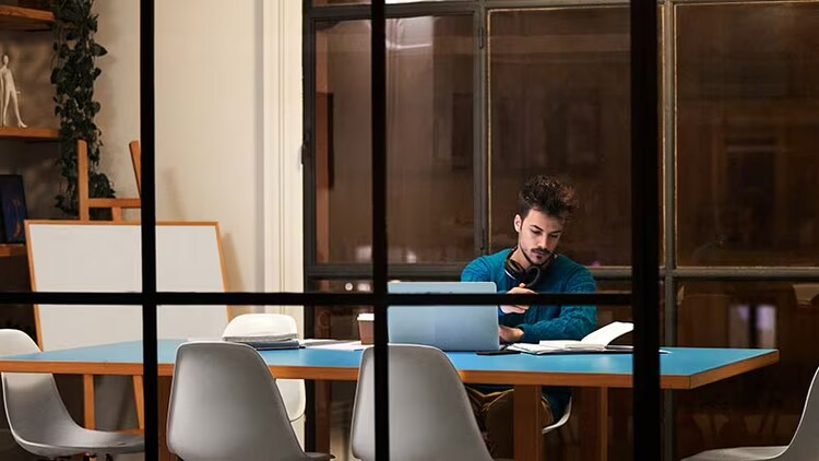 Long IT security workdays: man in a conference room working by himself