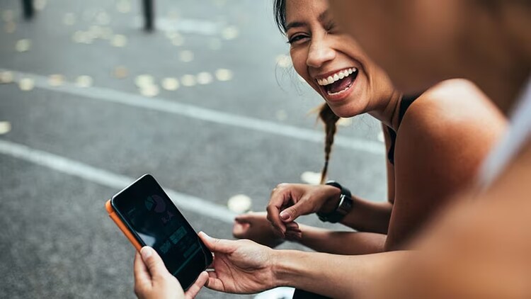 Customer experience: 2 girls looking at phone and smiling