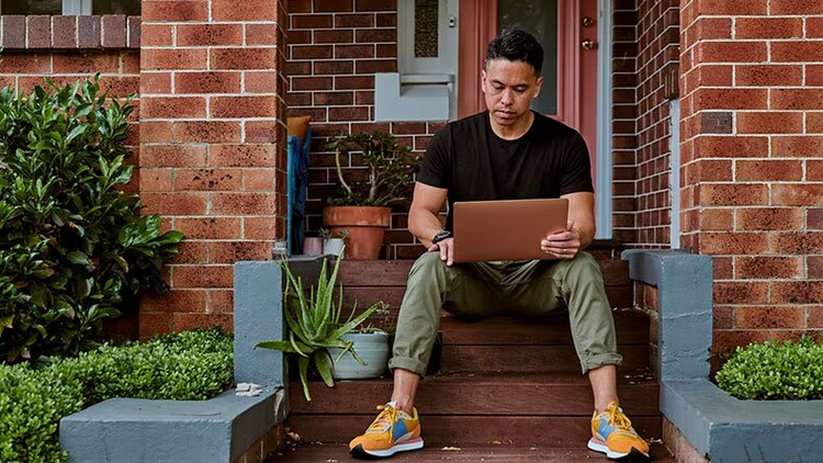 ITAM or configuration management? Man sitting on steps outside his house working on laptop