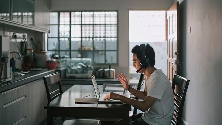 Great experiences from ServiceNow and Zoom: man sitting at a table waving at his computer screen