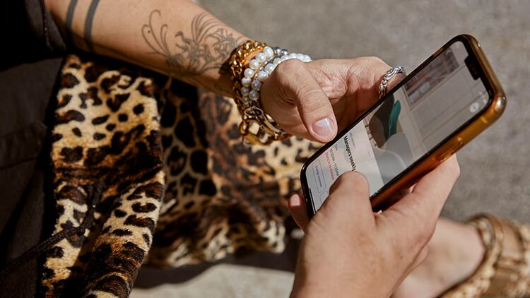 Improving ITSM and customer service with automation: A person holds a smartphone.