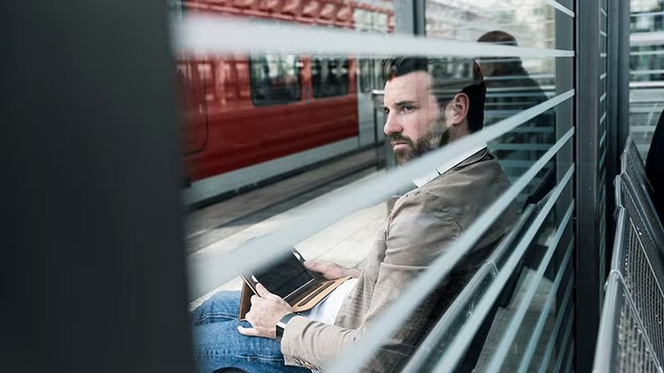 Cybersecurity: man sits on train bench with a tablet