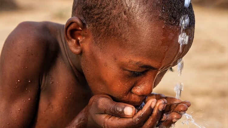 ServiceNow and GivePower: Kenyan boy drinking water out of his hands