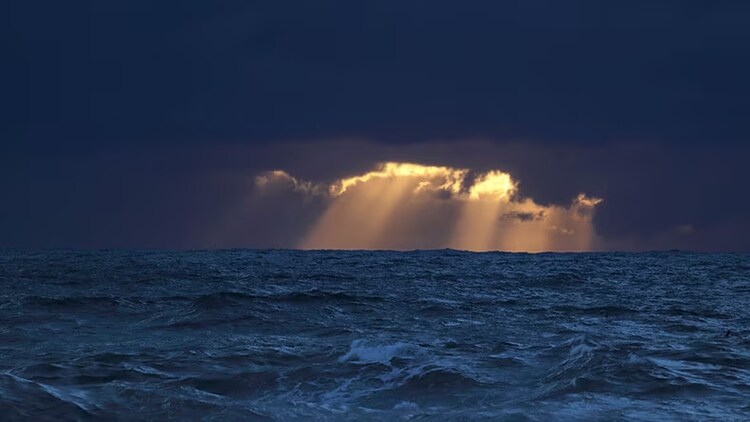 Opportunities in global uncertainty: sun shining through clouds over waves