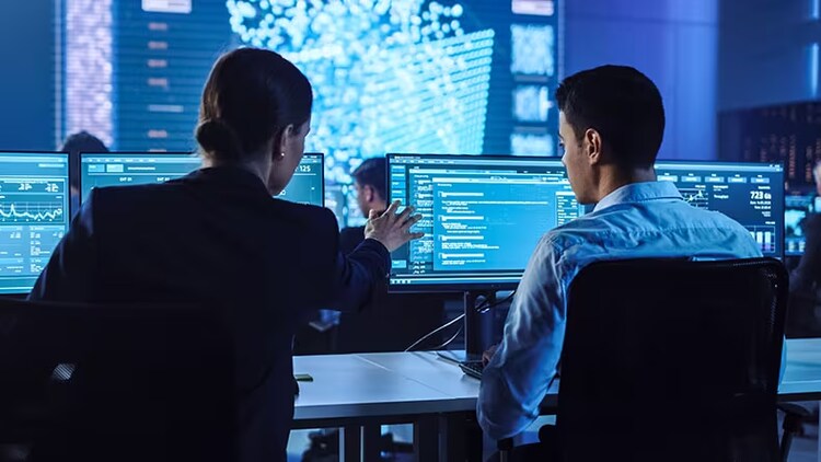 Red team: two security workers looking at info on computer screens