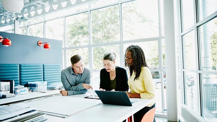 HR digital transformation: 3 employees collaborate over a conference table