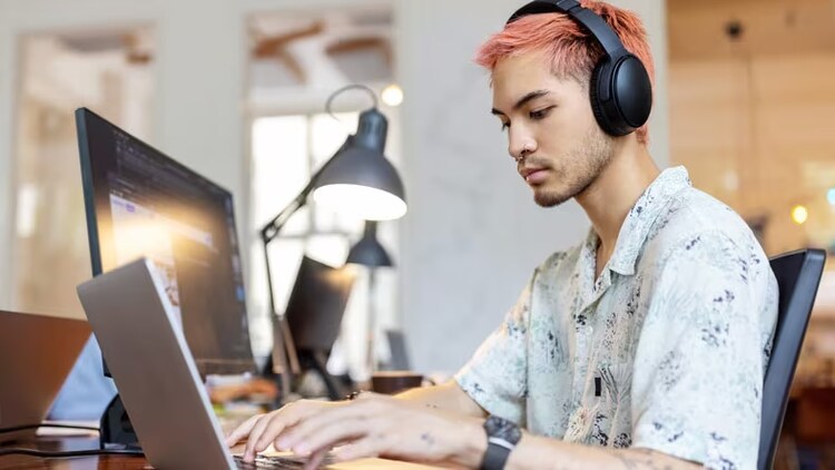 Low-code: man with earphones working on a laptop