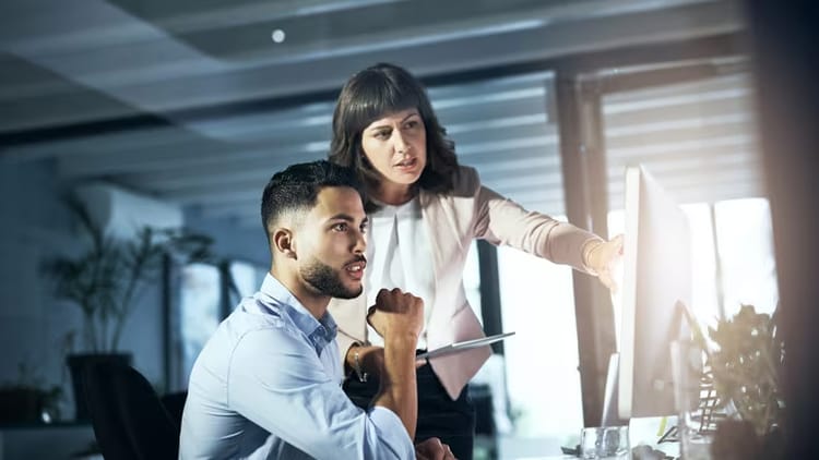 Man and woman looking at computer screen in an office