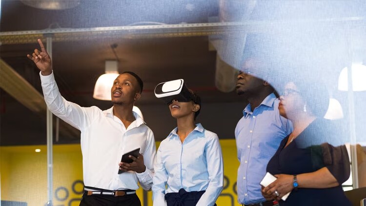 Future of digital learning: Woman wearing a virtual reality headset while 3 others look on