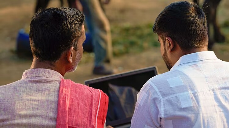 Visibility to tame digital elephant: 2 Indian workers outdoors looking at laptop