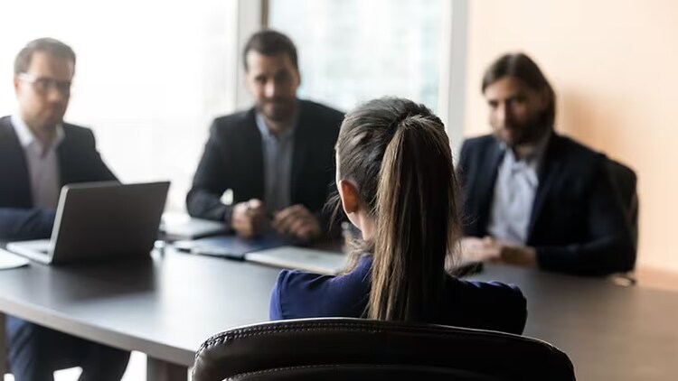Digitizing employee experience: group of 4 workers gathered around a conference table