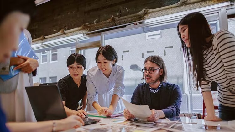 RPA: group of workers gathered around a conference table looking at a laptop