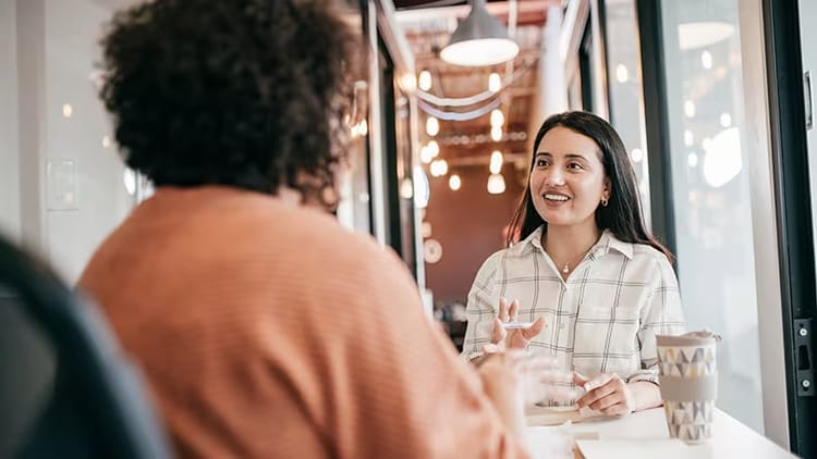 Career shift: two women in conversation at a table in an office