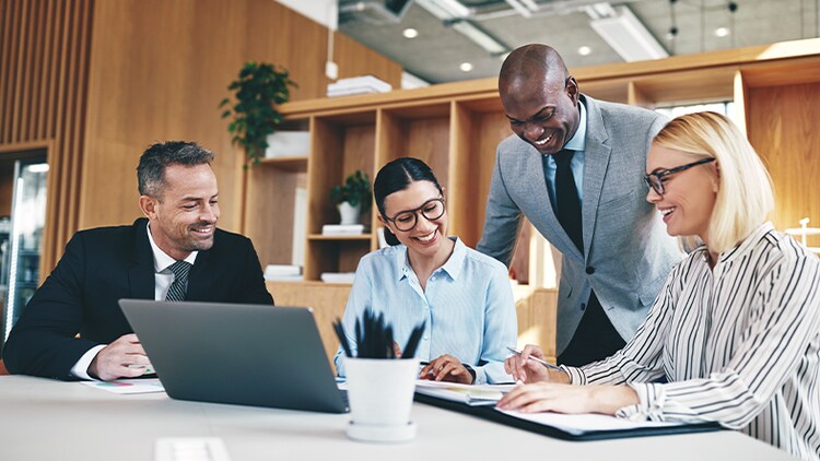 Change adoption involves meeting with stakeholders, as depicted by these four people collaborating at a conference table.