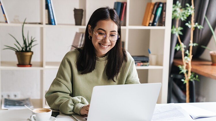 Career journeys: woman smiling and typing on a laptop