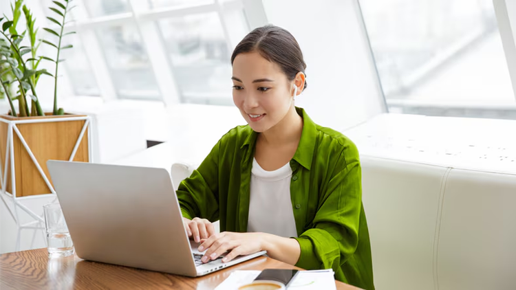 GenAI roadmap: woman working on a laptop in bright office
