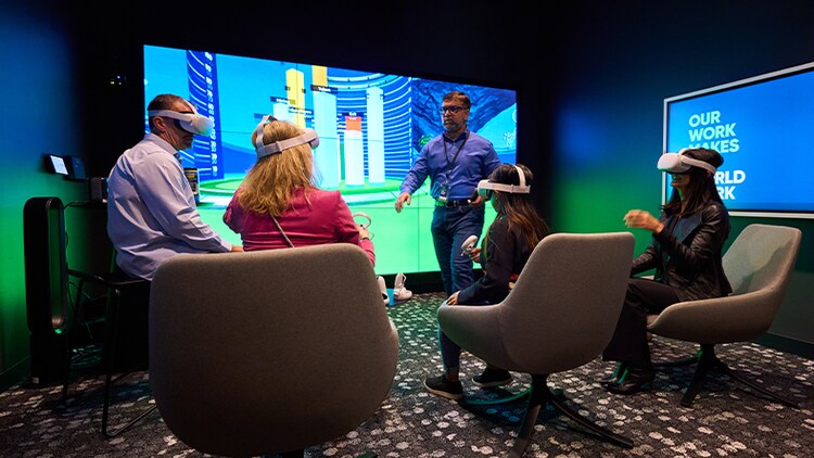 Four HR executives visualizing data using virtual reality (VR) headsets
