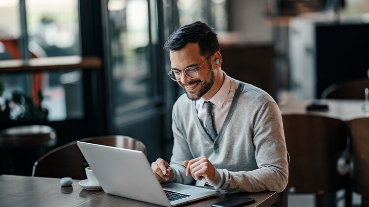 Cloud Solutions: man in a cafe using a laptop