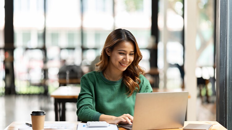 Career coaching: woman smiling at an open laptop