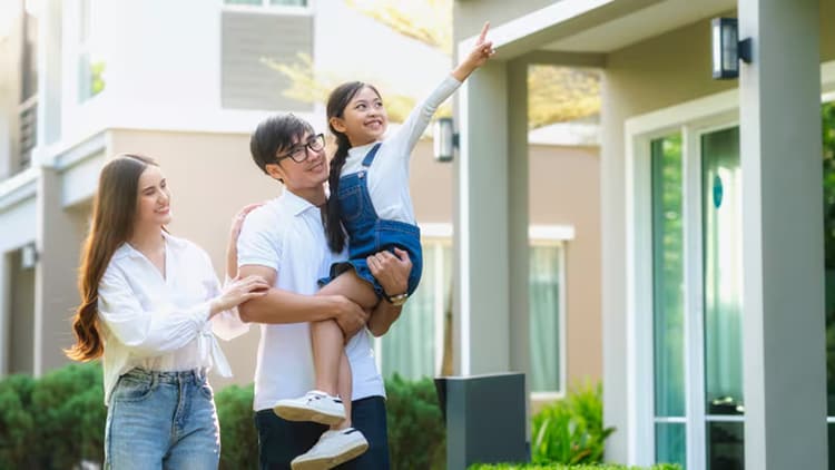 Young family in front of their new home