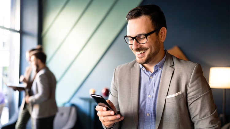 Zero-copy data access: man in a bright office smiling at a phone in his hand